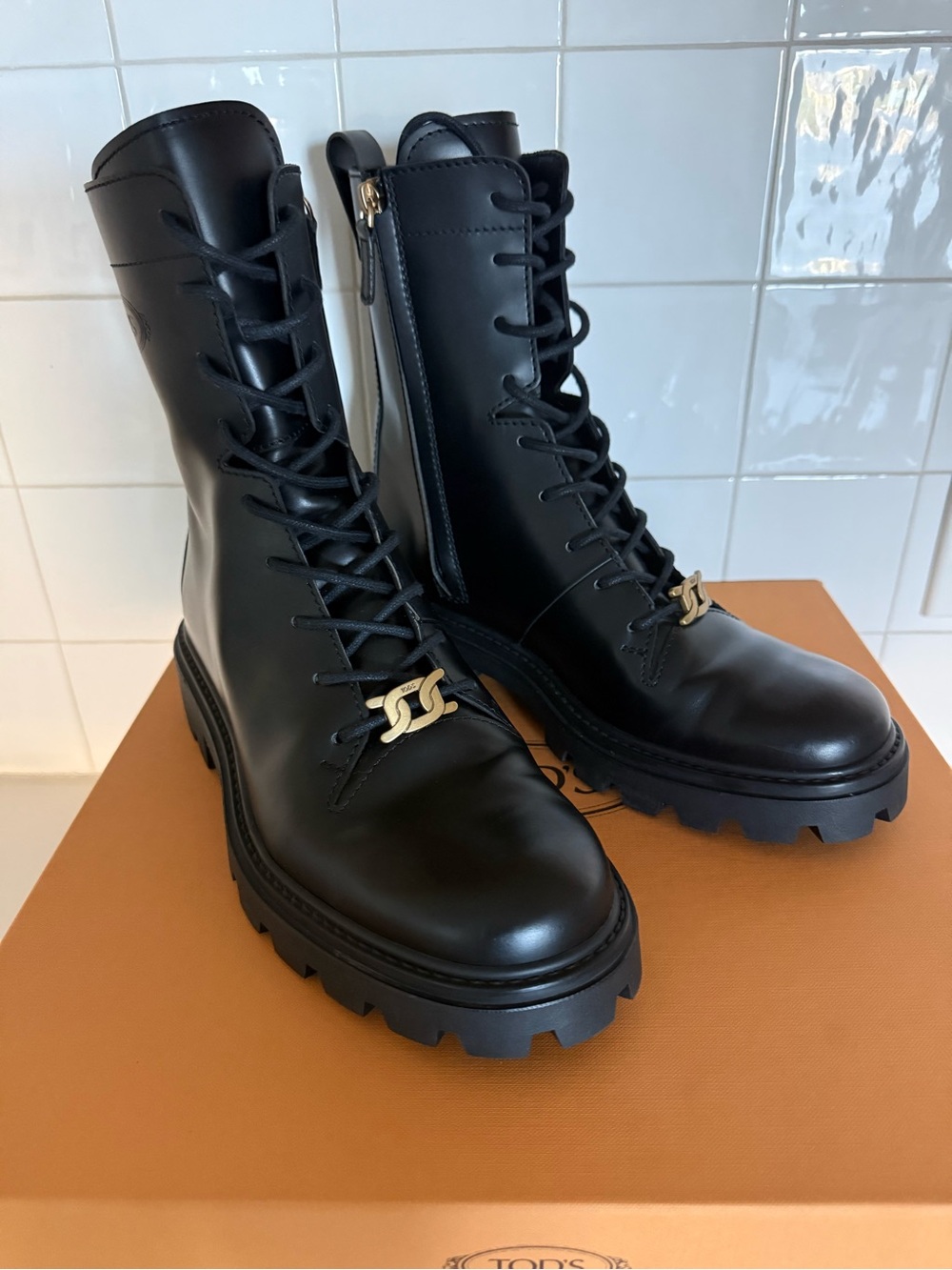 Tod's Black Leather Lug Sole Combat Boots with Gold Accent